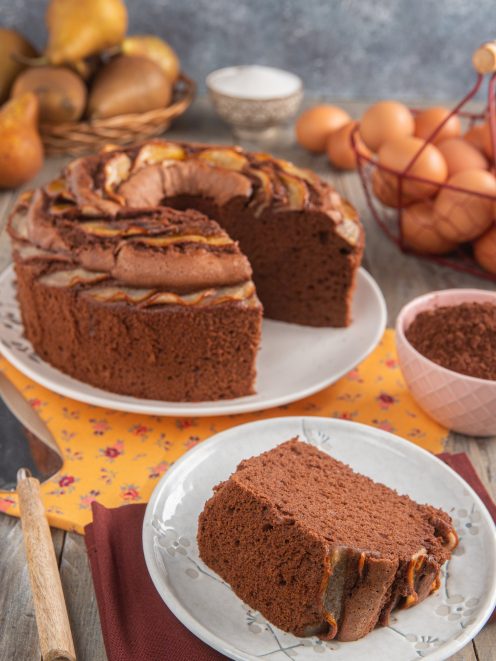 Chiffon cake alle pere e cioccolato con fette di pera caramellata, una porzione tagliata in primo piano