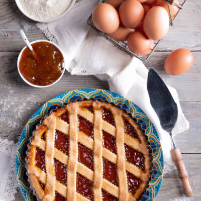 Crostata all'albicocca con reticolo di pasta frolla dorata e marmellata lucida