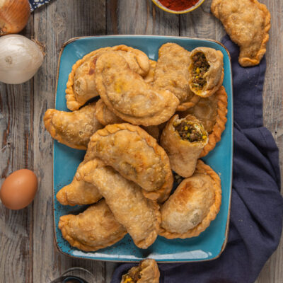 Empanadas argentine di carne fritte, alcune aperte con ripieno di carne macinata e uova sode