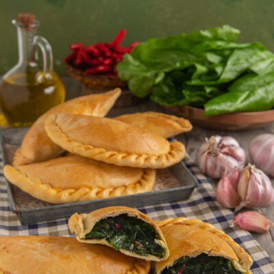 Falagoni lucani ripieni di verdure a foglia verde, uno aperto a mostrare il cuore filante