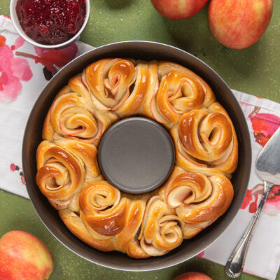 Ghirlanda di rose alle mele appena sfornata in uno stampo a corona, dorata e lucida di glassa