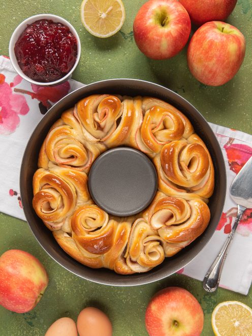 Ghirlanda di rose alle mele appena sfornata in uno stampo a corona, dorata e lucida di glassa