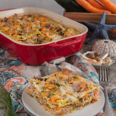 Lasagne di mare con salmone, zucchine, carote e aneto servite a fetta