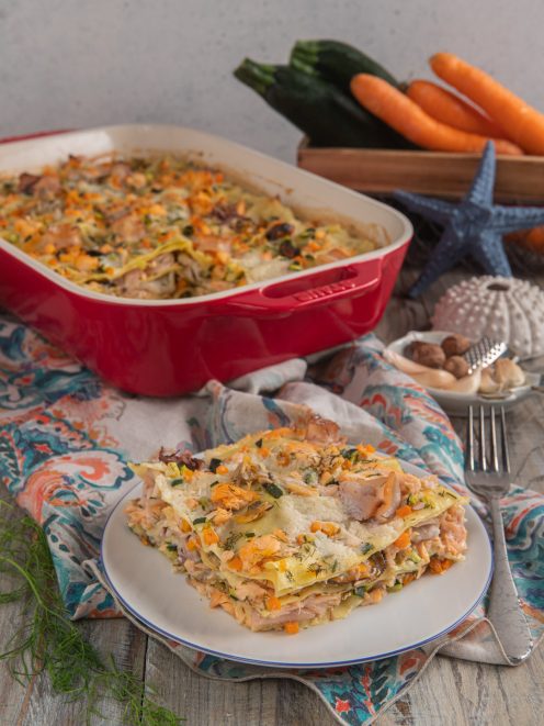 Lasagne di mare con salmone, zucchine, carote e aneto servite a fetta