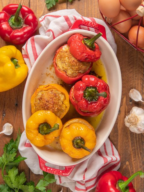 Peperoni ripieni di carne rossi e gialli appena sfornati con ripieno dorato in teglia