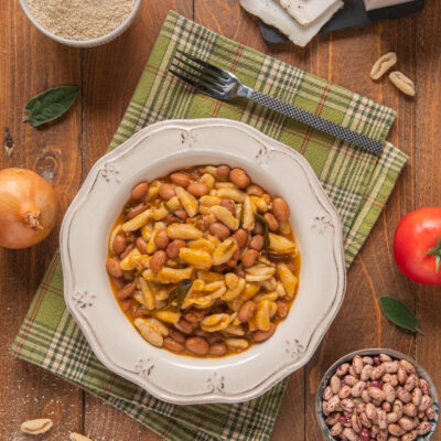 Pisarei e fasò con fagioli borlotti in brodo denso di pomodoro e foglie di salvia