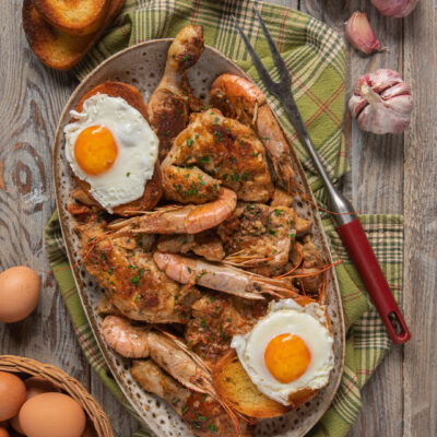 Pollo alla marengo con gamberi, uova al tegamino e crostoni di pane dorato