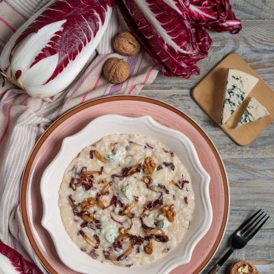 Risotto al radicchio e gorgonzola cremoso, guarnito con noci e foglie di radicchio saltate