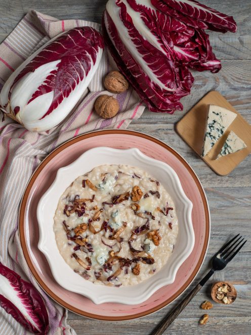 Risotto al radicchio e gorgonzola cremoso, guarnito con noci e foglie di radicchio saltate