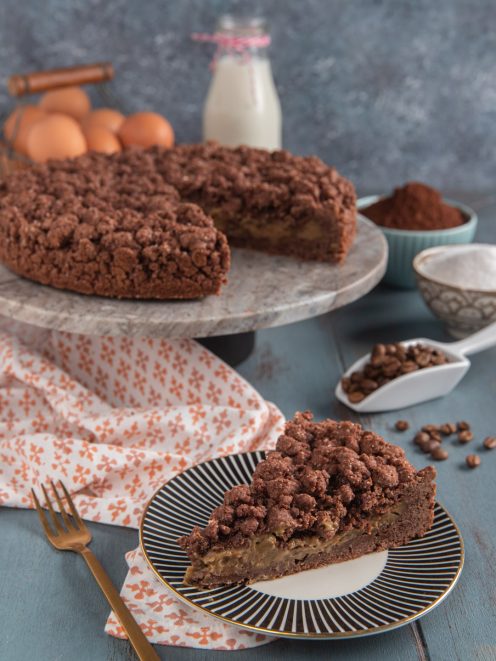 Sbriciolata al caffè con crema al centro, torta intera e fetta servita nel piatto