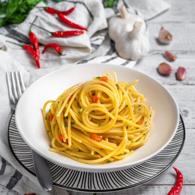 Spaghetti aglio olio e peperoncino conditi con prezzemolo tritato e pezzetti di peperoncino rosso
