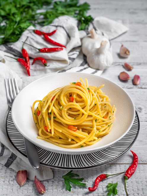 Spaghetti aglio olio e peperoncino conditi con prezzemolo tritato e pezzetti di peperoncino rosso