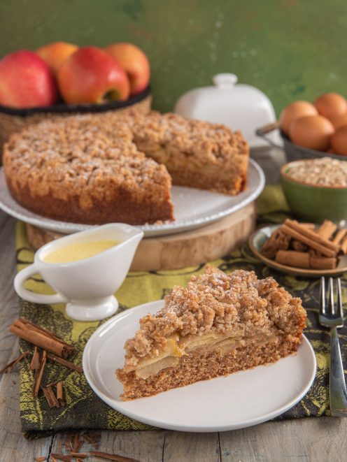 Torta alle mele irlandese sbriciolata con fette di mela e crema versata a lato