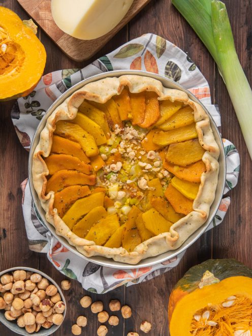 Torta salata zucca e nocciole con fette disposte a raggiera e granella al centro