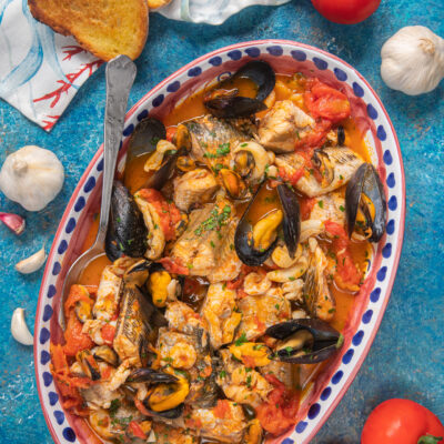 Zuppa di pesce con cozze aperte, pezzi di pesce e pomodoro in brodetto saporito, guarnita con prezzemolo