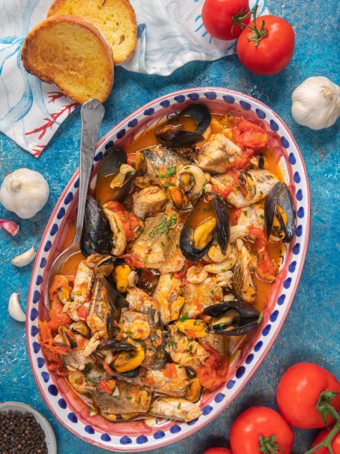 Zuppa di pesce con cozze aperte, pezzi di pesce e pomodoro in brodetto saporito, guarnita con prezzemolo