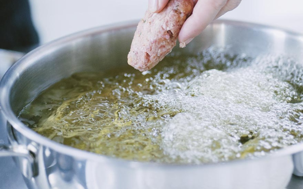 Una polpetta di carne cruda calata a mano nell'olio bollente e spumeggiante