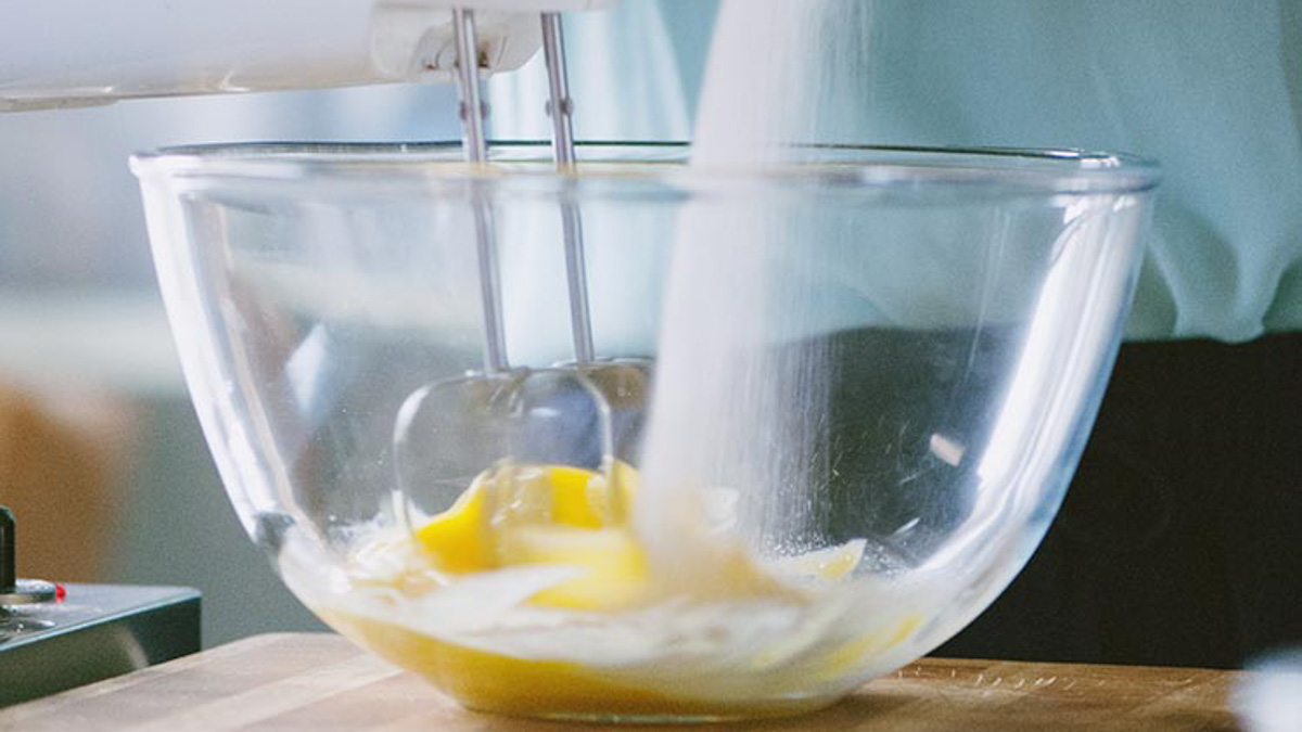 Uova e zucchero montati con le fruste elettriche fino a ottenere un composto chiaro e spumoso