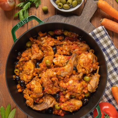 Coniglio alla cacciatora con salsa di pomodoro, olive verdi e nere e carote a dadini