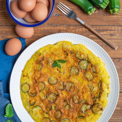 Frittata alle zucchine dorata con rondelle di zucchina e foglioline di menta