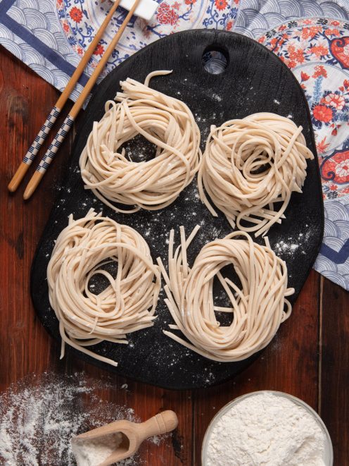 Quattro nidi di noodles freschi crudi infarinati, pronti per la cottura