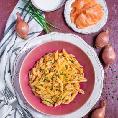 Pasta panna e salmone con penne condite con pezzi di salmone e erba cipollina tritata