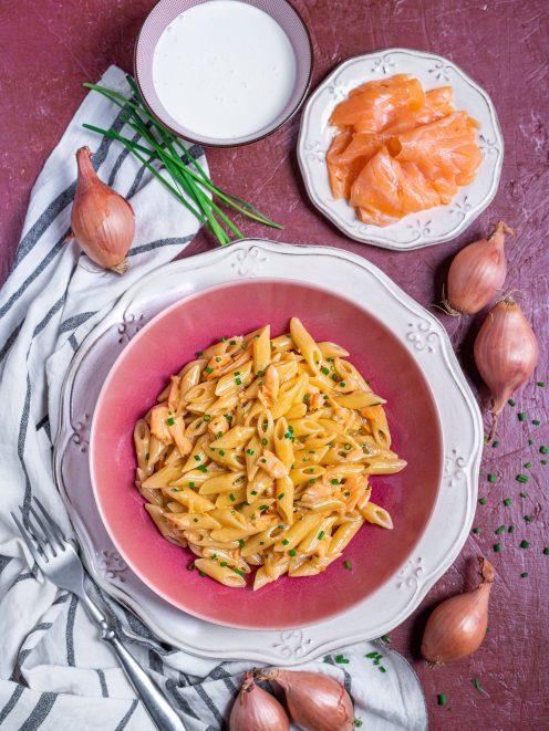 Pasta panna e salmone con penne condite con pezzi di salmone e erba cipollina tritata