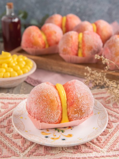 Pesche dolci sarde ricoperte di zucchero colorato con farcitura di crema gialla