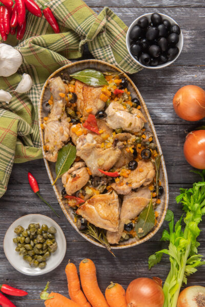 Pollo alla cacciatora in bianco con olive nere, peperoncino, carote e foglie di alloro