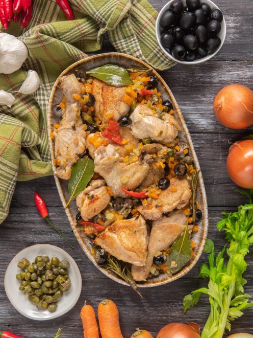 Pollo alla cacciatora in bianco con olive nere, peperoncino, carote e foglie di alloro