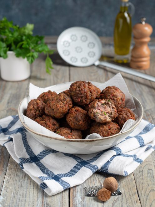 Polpette fritte di carne dorate e croccanti, servite in ciotola con carta assorbente