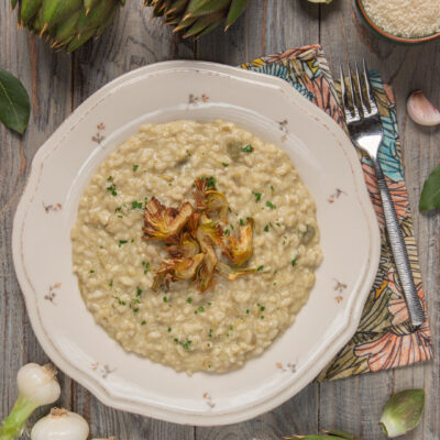 Risotto ai carciofi cremoso con cuori di carciofo arrostiti al centro e prezzemolo tritato