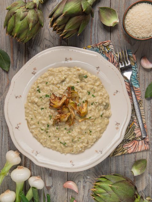 Risotto ai carciofi cremoso con cuori di carciofo arrostiti al centro e prezzemolo tritato