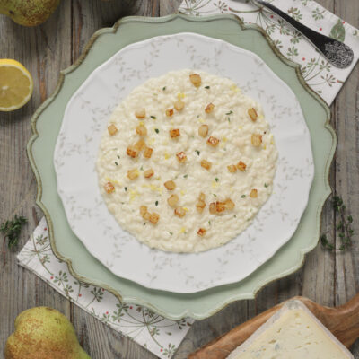 Risotto gorgonzola e pere cremoso, guarnito con cubetti di pera saltati e foglioline di timo