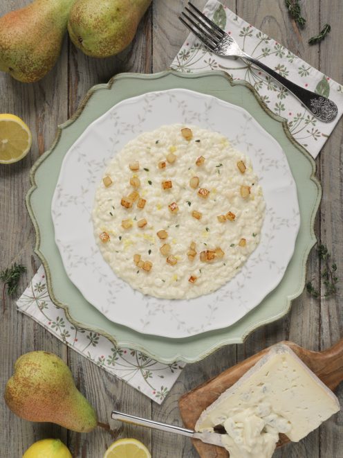 Risotto gorgonzola e pere cremoso, guarnito con cubetti di pera saltati e foglioline di timo