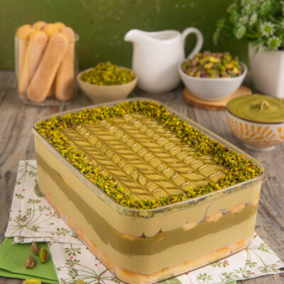 Tiramisù al pistacchio a strati con crema decorata e granella di pistacchi in superficie