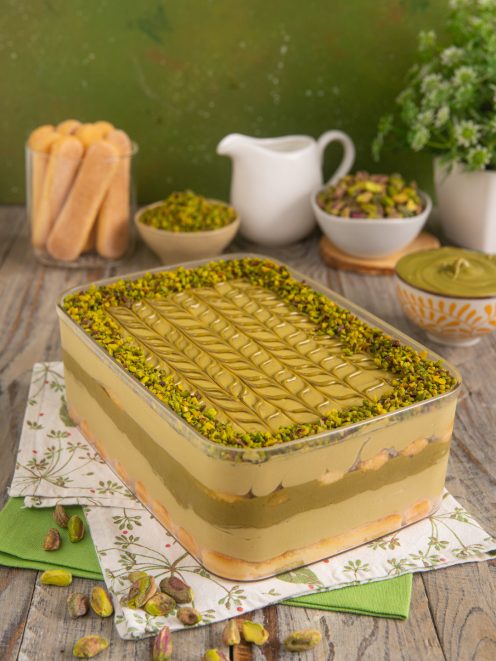 Tiramisù al pistacchio a strati con crema decorata e granella di pistacchi in superficie
