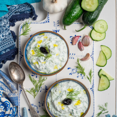 Tzatziki con cetriolo, aneto fresco, oliva nera e filo d'olio, servito in due ciotole