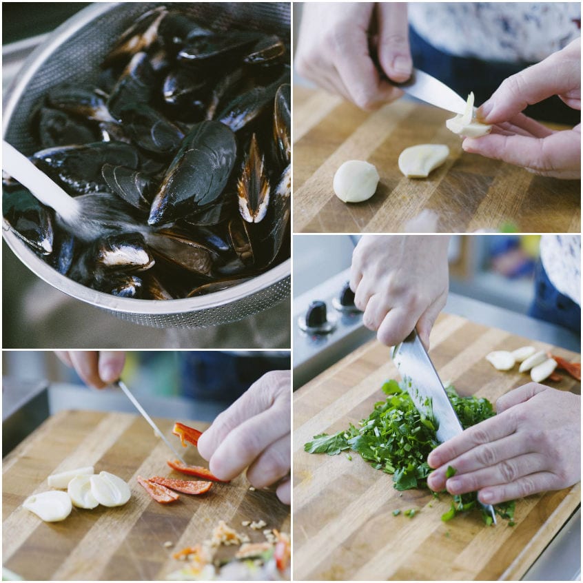 Cozze in scolapasta, aglio mondato, peperoncino affettato e prezzemolo tritato sul tagliere