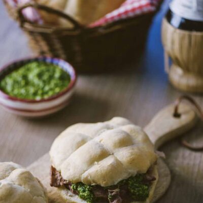Panino col lampredotto farcito con trippa e salsa verde su tagliere