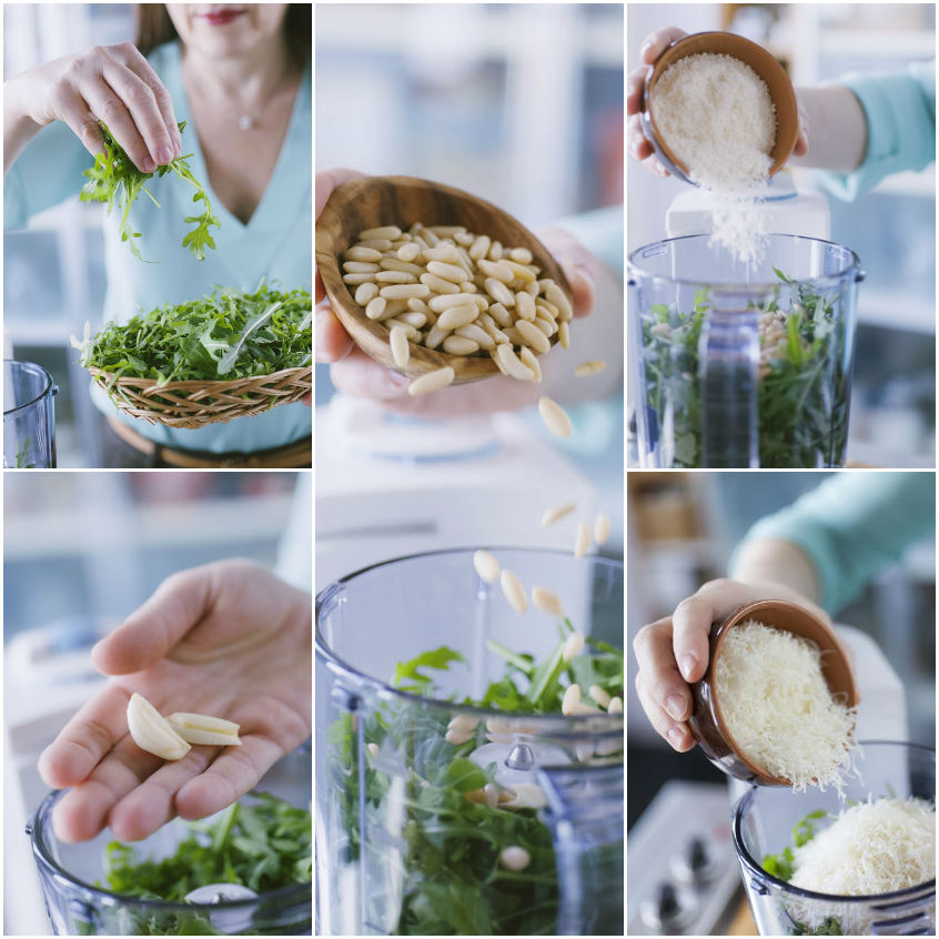 Ingredienti del pesto di rucola aggiunti nel frullatore: foglie fresche, pinoli, aglio e formaggio grattugiato