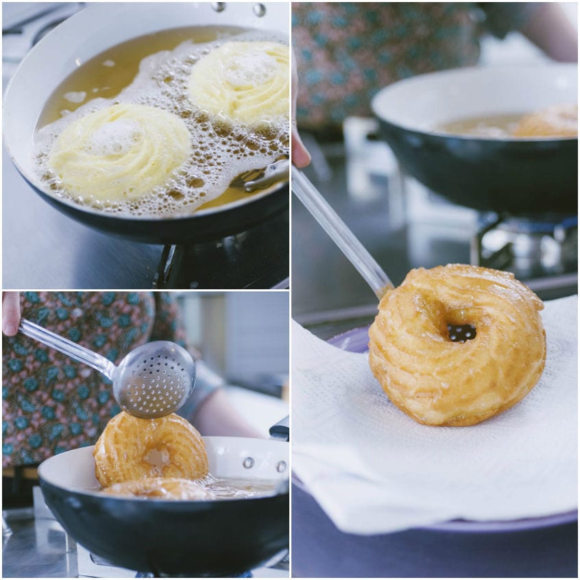 Zeppole fritte scolate con il mestolo forato e appoggiate su carta assorbente