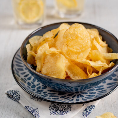 Chips di patate croccanti servite in abbondanza, con qualche fettina sparsa intorno
