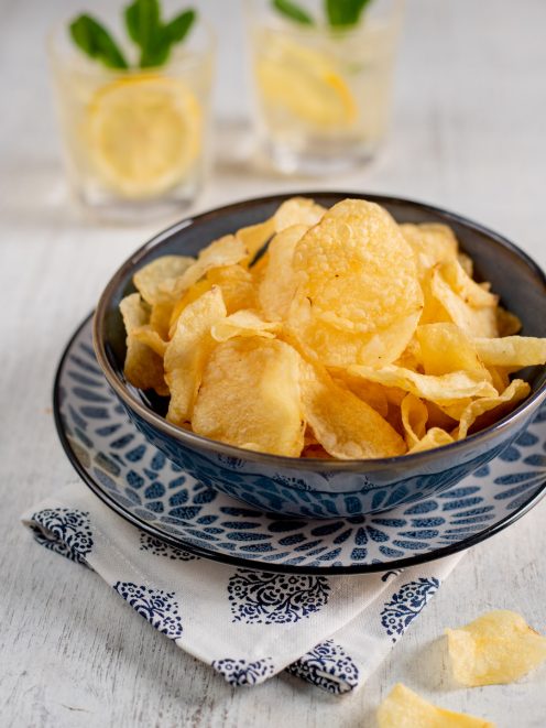 Chips di patate croccanti servite in abbondanza, con qualche fettina sparsa intorno