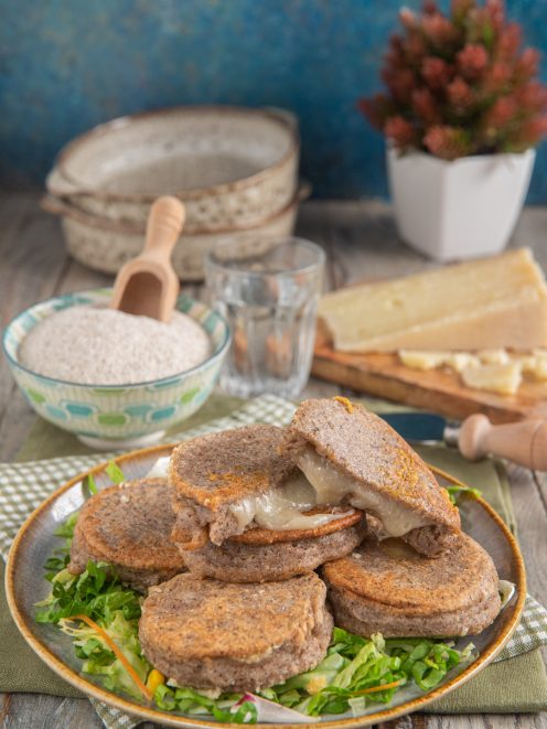 Chisciöi di grano saraceno filanti di formaggio adagiati su un letto di insalata sfilettata