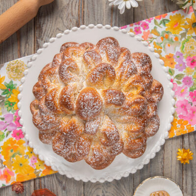 Fior di brioche a forma di petali dorati spolverata di zucchero a velo