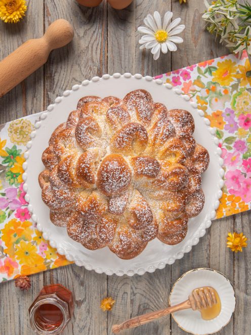 Fior di brioche a forma di petali dorati spolverata di zucchero a velo