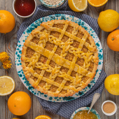 Marmalade treacle tart con copertura a intreccio di pasta frolla, circondata da agrumi freschi