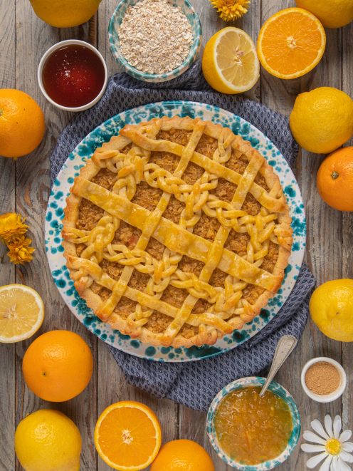 Marmalade treacle tart con copertura a intreccio di pasta frolla, circondata da agrumi freschi