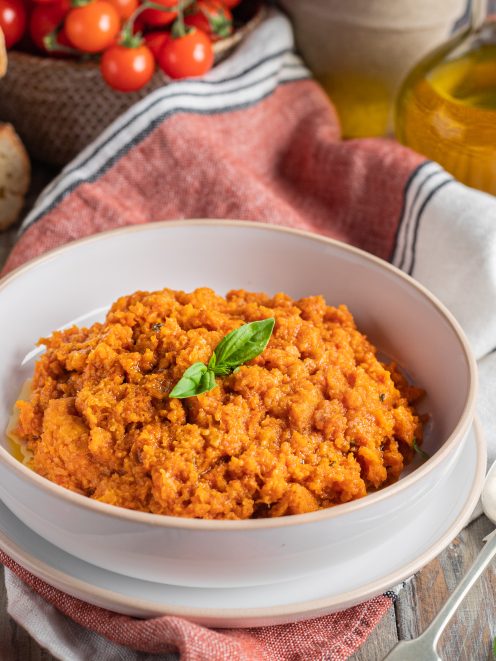 Pappa al pomodoro servita in ciotola, densa e rustica, guarnita con foglie di basilico fresco